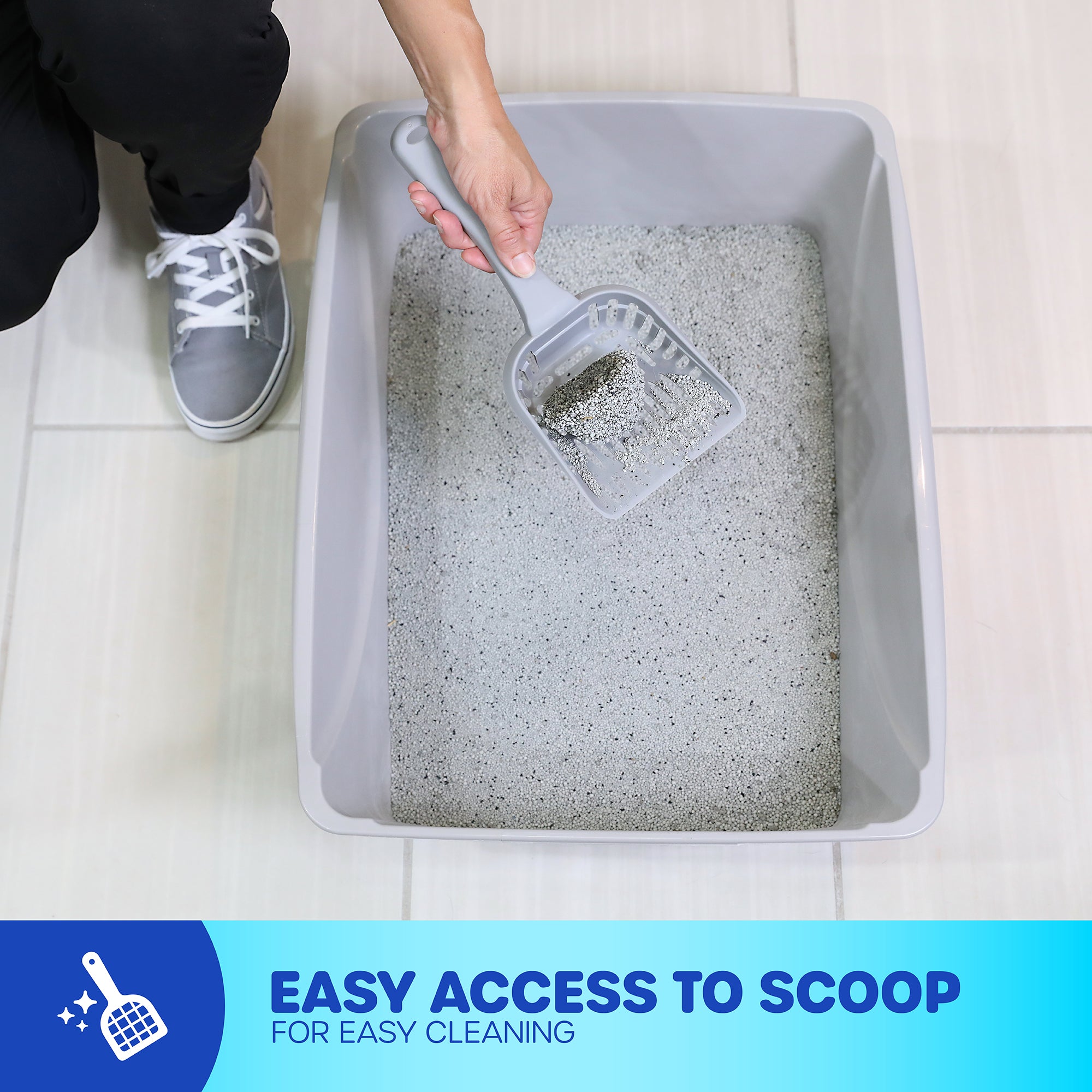 A person wearing gray sneakers cleans a large, gray Pet-mates Basic Litter Box made from EcoTech™ resin using a scooper. The open-top design offers easy access. A blue banner states: Easy access to scoop for easy cleaning.
