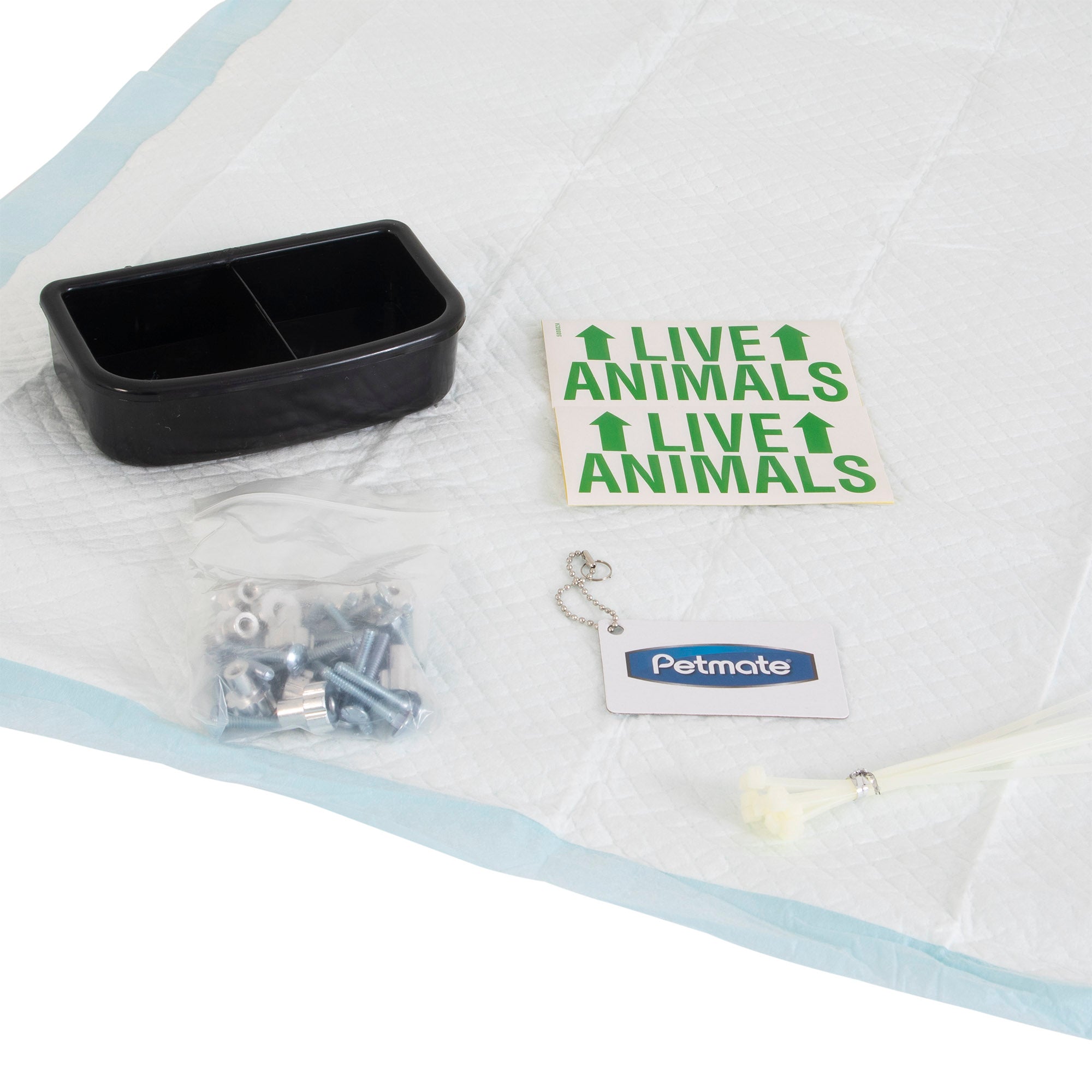 The Pet-mates Kennel Airline Travel Kit by Pet-mates is ideal for air travel, including a black dual-section dish, Live Animals stickers, a plastic bag with metal bolts and wing nuts, an ID tag with chain, zip ties, and kennel accessories all organized on a disposable pet pad.