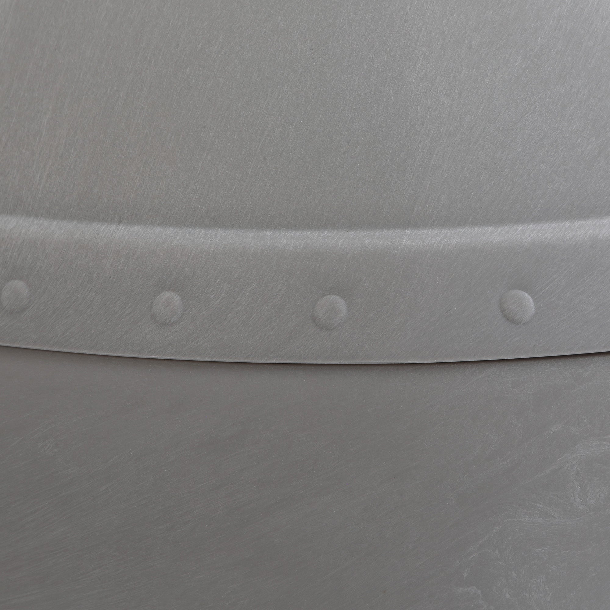 Close-up of the Pet-mates Husky Dog House by Pet-mates, showcasing a metallic surface with a lightly brushed texture and a curved seam accented by evenly spaced rivets for an industrial look.