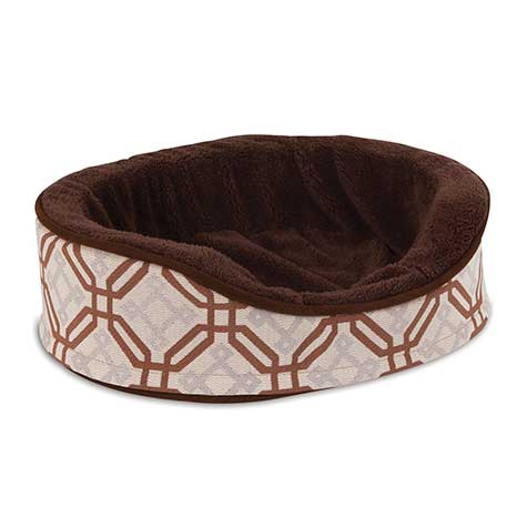 The Pet-mates Small Dog & Cat Oval Foam Fashion Bed by Pet-mates offers a plush brown interior and a chic exterior with an interlocking brown and white geometric pattern. Its raised sides enhance comfort, and the bed is machine washable for effortless care.