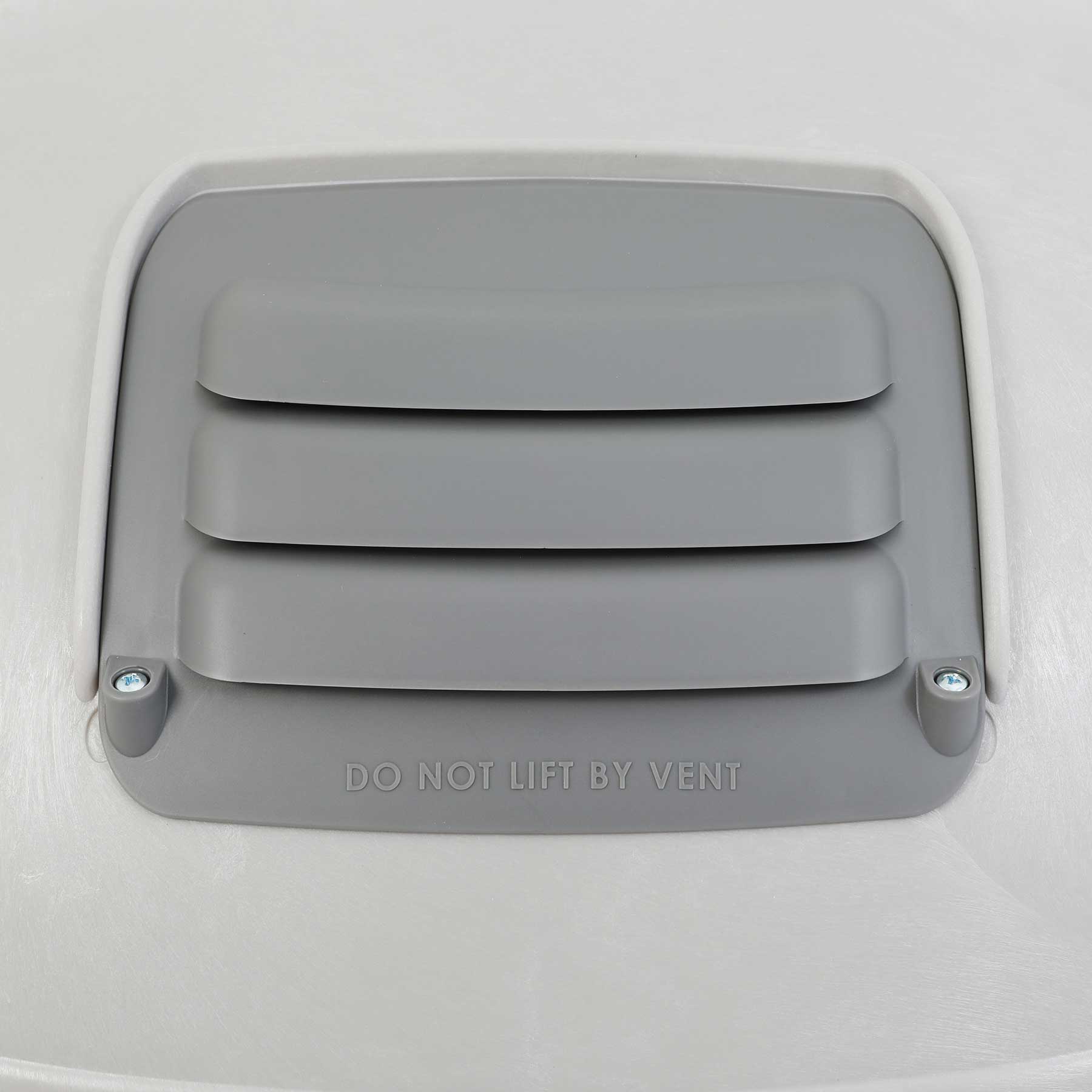 The Pet-mates Husky Shelter Vent Kit features a gray cover with horizontal slats, DO NOT LIFT BY VENT embossed below, and is secured with two screws on a smooth, light-colored surface to ensure your pets safety.