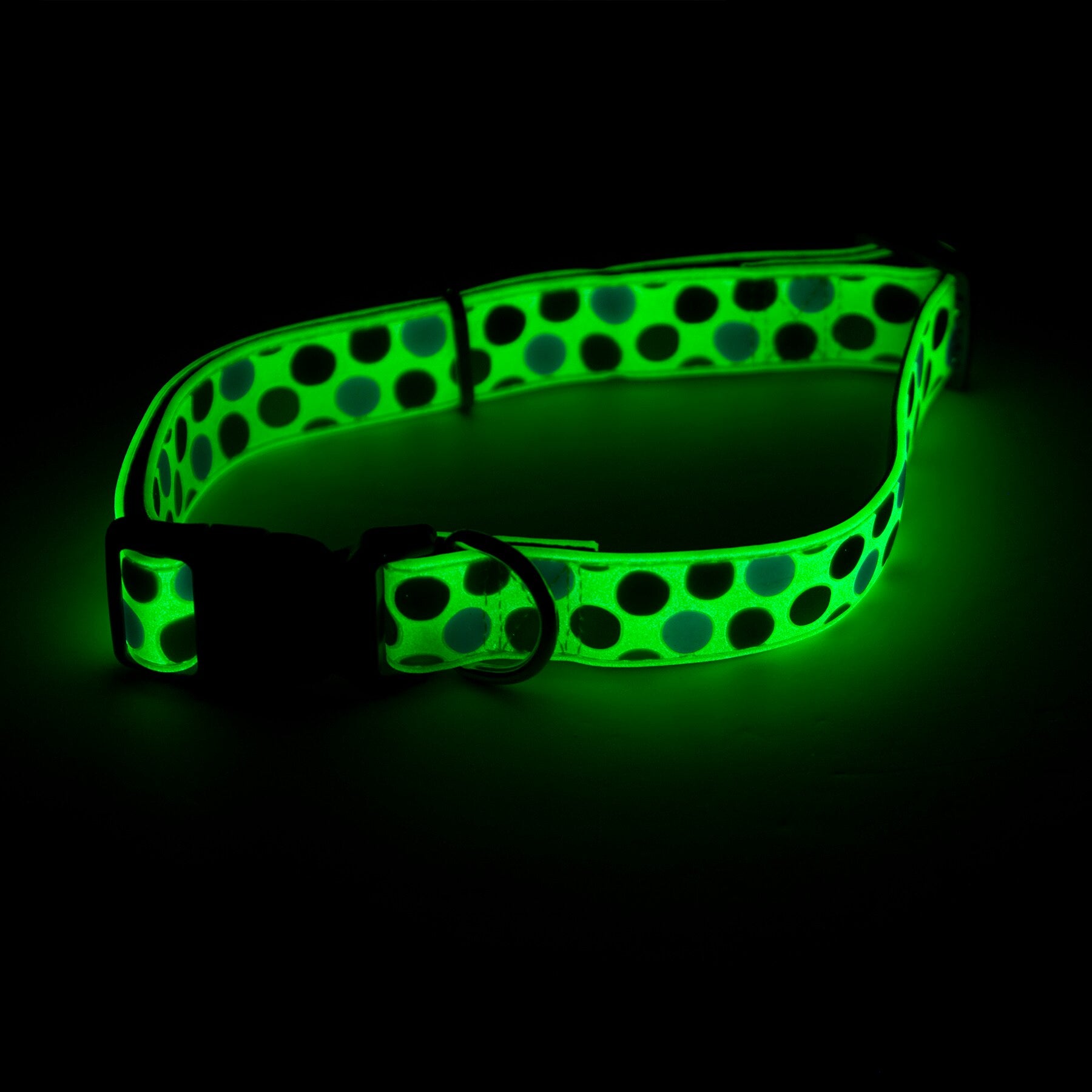 The Pet-mates Green Dots Glow in the Dark Dog Collar, adorned with black polka dots, features a buckle and D-ring, ensuring safety and style for your dog in dark settings.